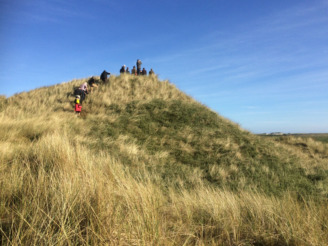 wandelaars bereiken de top van de Boschplaat op Terschelling.